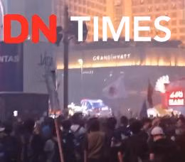 Demonstran memanjat pos polisi di Bundaran HI dan menyalakan flare, Rabu malam (28/10/2026). (IDN Times/Dini Sucianingrum)